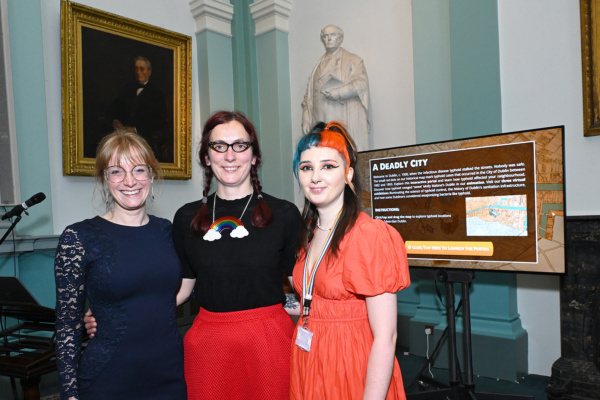 Carly Collier (Typhoidland), Harriet Wheelock (Keeper of Collections, RCPI) and Chiara Morgan (Assistant Keeper of Collections, RCPI), in front of Typhoidland's Dublin digital portal, 13th June. Picture Credit: Bobby Studio.